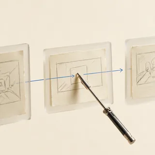 Storyboard frames on glass, a stylus tracing the throughline.